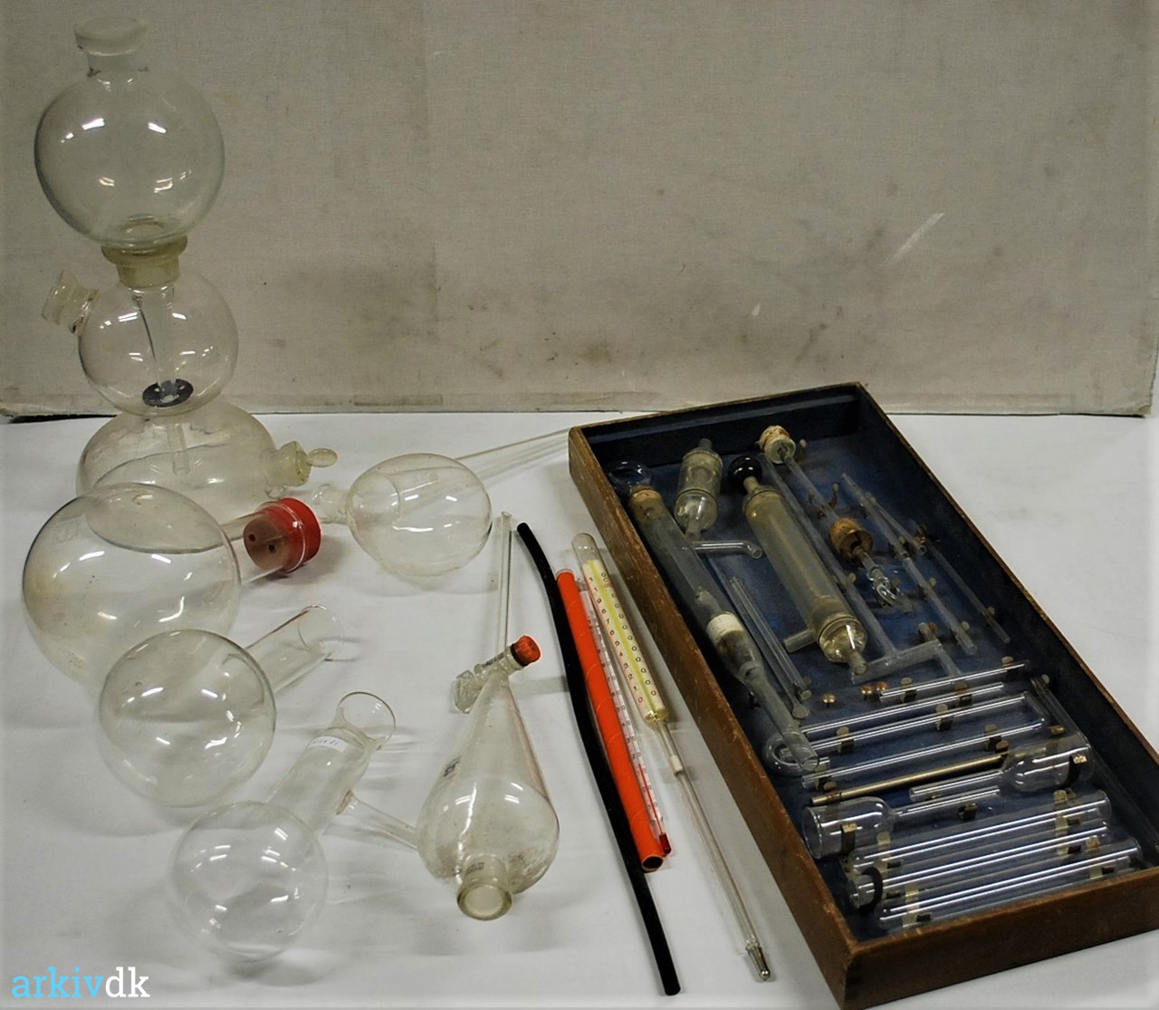 arkiv.dk | Fysik- og kemiinstrumenter - Glaskolber og glasrør til kemiforsøg i trækasse, andre kolber glas. 9 effekter